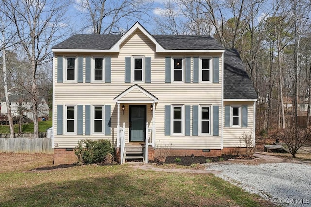 colonial-style house featuring crawl space, a front yard, fence, and roof with shingles