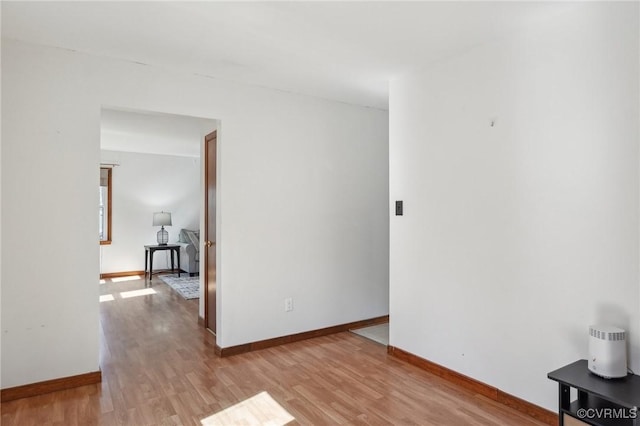 unfurnished room with baseboards and light wood-style floors