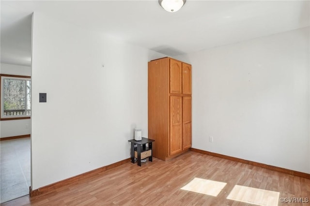 spare room with light wood-style floors and baseboards