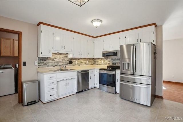 kitchen with decorative backsplash, appliances with stainless steel finishes, light countertops, and a sink