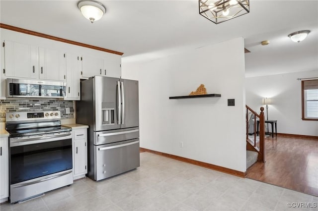 kitchen featuring white cabinetry, baseboards, light countertops, appliances with stainless steel finishes, and backsplash