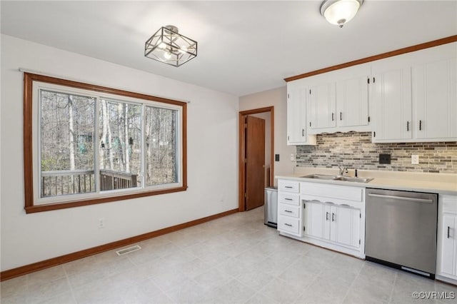 kitchen featuring a sink, visible vents, light countertops, stainless steel dishwasher, and tasteful backsplash