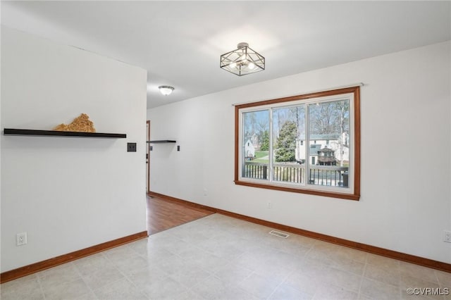 spare room with light floors, baseboards, and visible vents