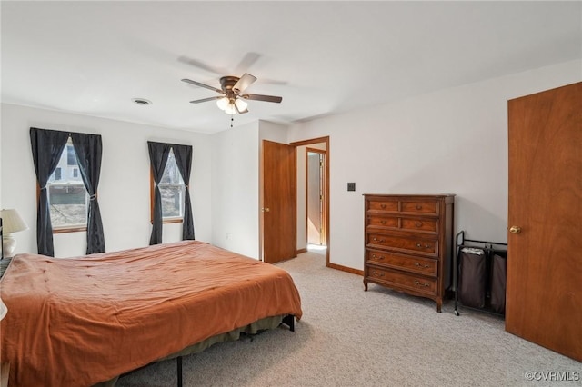 bedroom with visible vents, baseboards, a ceiling fan, and light colored carpet