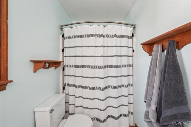 bathroom featuring a shower with shower curtain and toilet