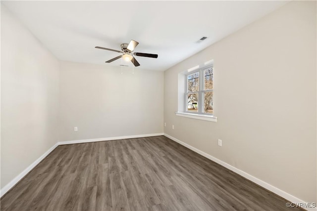 spare room with visible vents, ceiling fan, baseboards, and wood finished floors