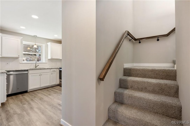 staircase featuring recessed lighting, baseboards, and wood finished floors