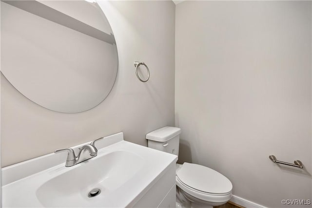 half bathroom with vanity and toilet