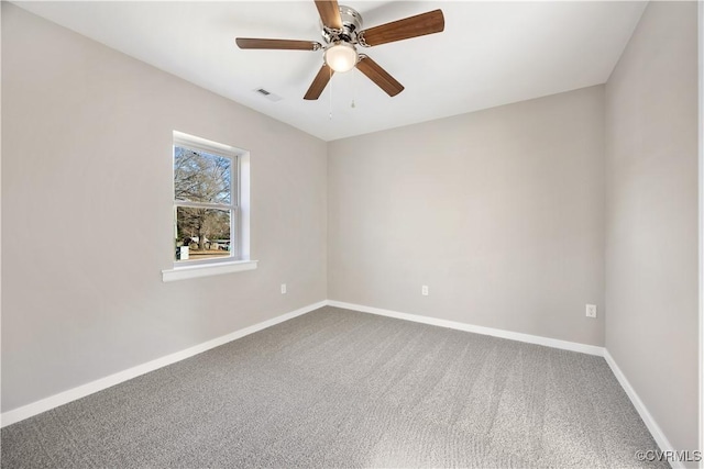 carpeted spare room featuring a ceiling fan, visible vents, and baseboards