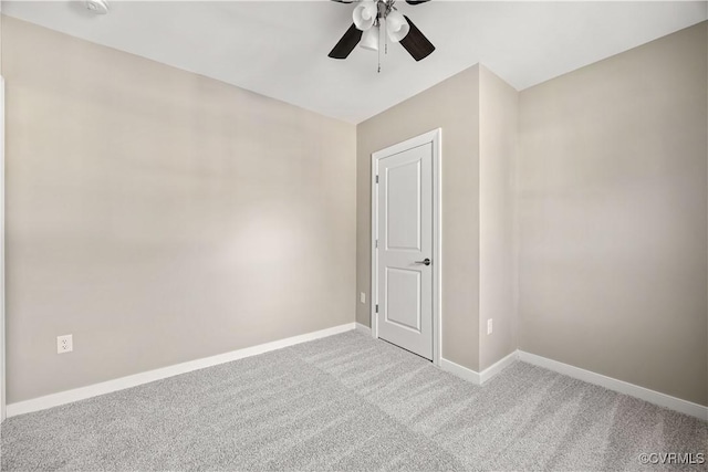 spare room featuring carpet floors, ceiling fan, and baseboards