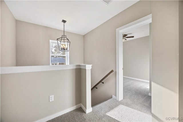 staircase featuring carpet, baseboards, and a chandelier