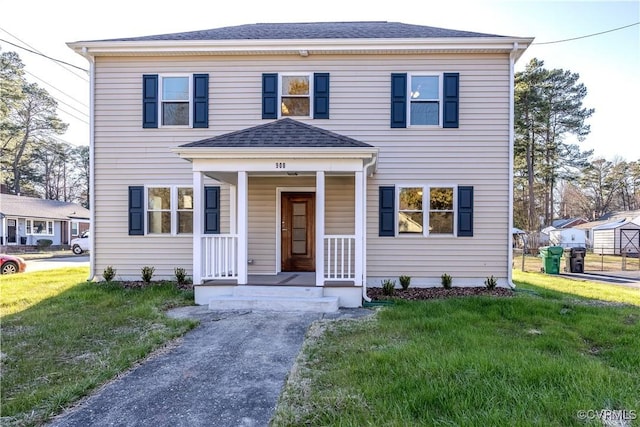 view of front of house featuring a porch, a front yard, and a shingled roof