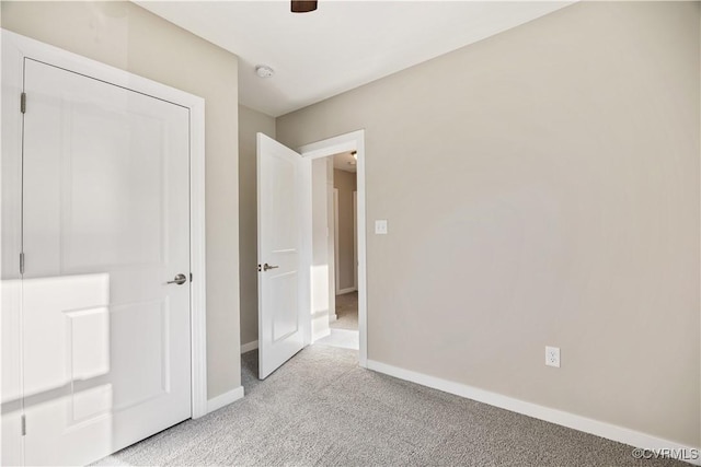 unfurnished bedroom featuring baseboards, ceiling fan, and light colored carpet