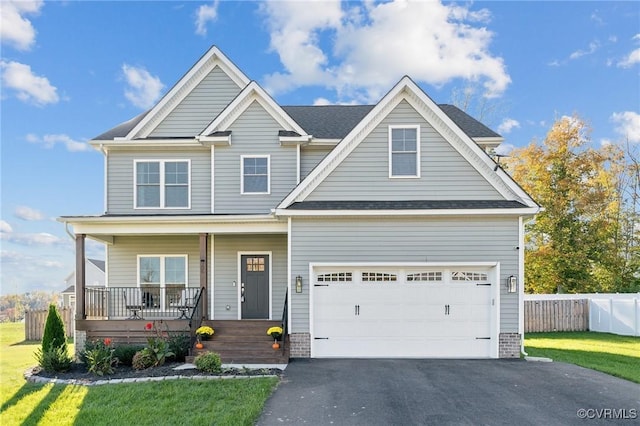 craftsman house featuring aphalt driveway, covered porch, a garage, fence, and a front lawn