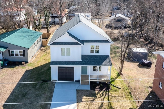 view of front facade featuring an attached garage, a shingled roof, fence, driveway, and a front lawn