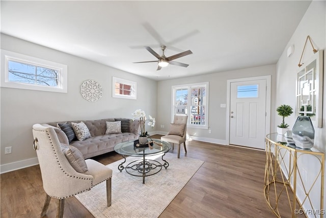 living room with a wealth of natural light, baseboards, and wood finished floors