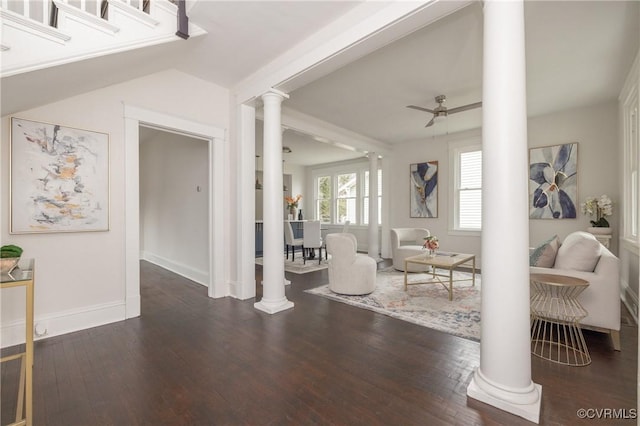 living room featuring wood finished floors, baseboards, decorative columns, ceiling fan, and vaulted ceiling