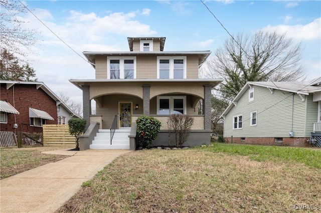 american foursquare style home with covered porch, a front yard, and fence