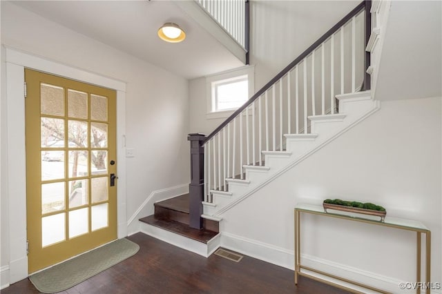 entryway with visible vents, baseboards, wood finished floors, and stairs