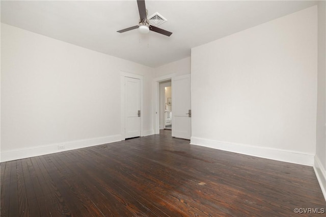 empty room featuring dark wood finished floors, visible vents, ceiling fan, and baseboards