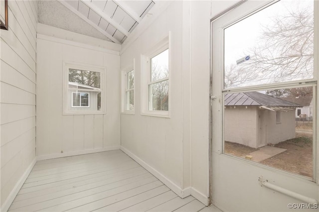 hall with lofted ceiling and wood finished floors