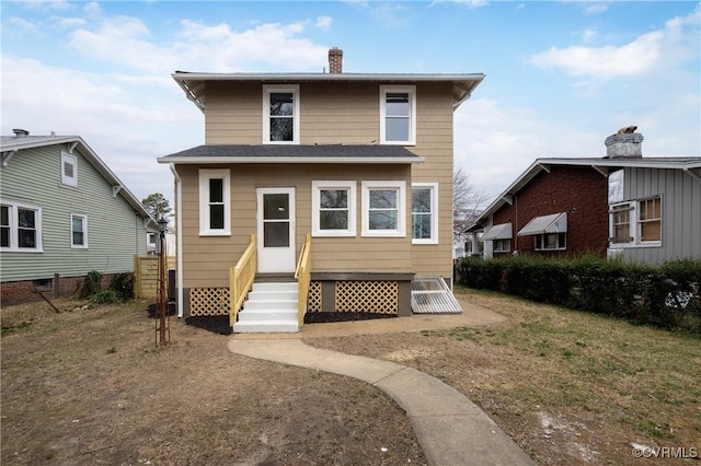 rear view of property with entry steps and a chimney