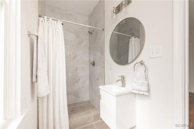 bathroom with vanity and tiled shower