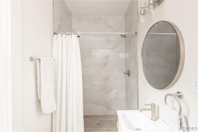 full bathroom featuring a sink, tiled shower, and tile patterned floors