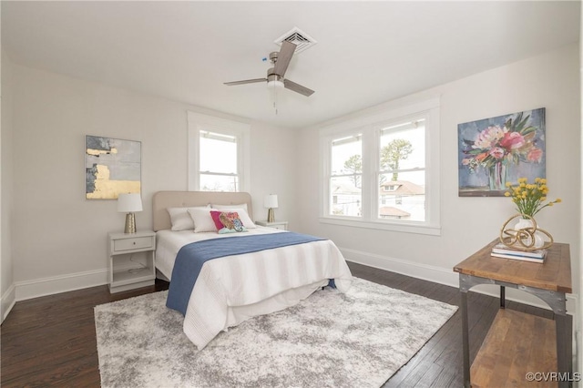 bedroom featuring ceiling fan, visible vents, baseboards, and dark wood finished floors