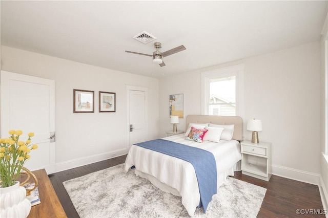 bedroom featuring visible vents, a ceiling fan, baseboards, and dark wood-style flooring