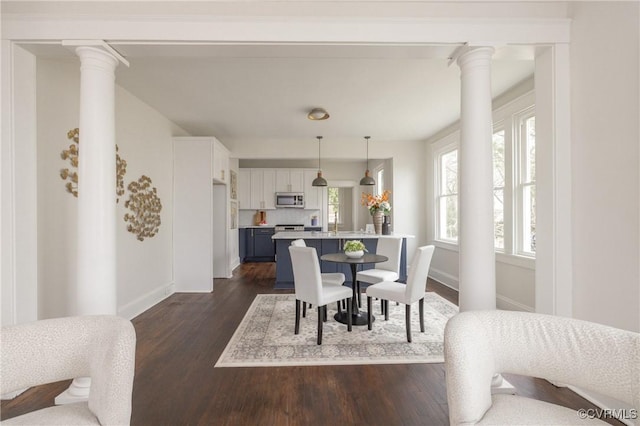 dining space with baseboards, ornate columns, and dark wood-style flooring