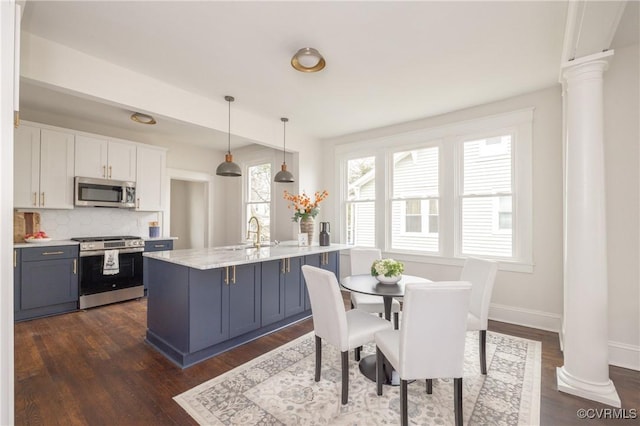 dining room with dark wood-style flooring, baseboards, and ornate columns