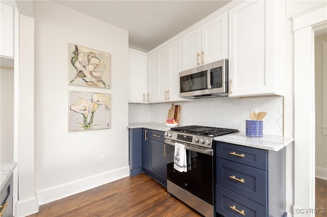 kitchen featuring dark wood-type flooring, decorative backsplash, appliances with stainless steel finishes, white cabinets, and blue cabinets