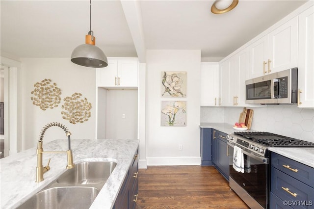 kitchen featuring tasteful backsplash, blue cabinetry, white cabinets, stainless steel appliances, and a sink