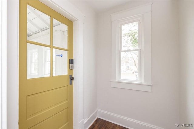 doorway to outside featuring baseboards and dark wood-style flooring