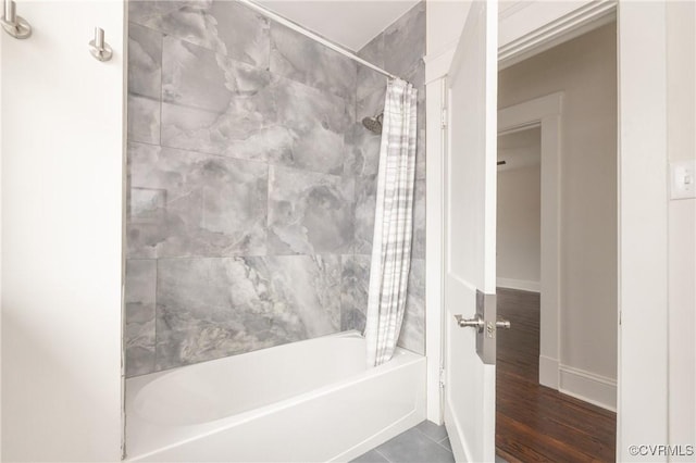 full bath featuring baseboards, shower / bath combo, and tile patterned flooring