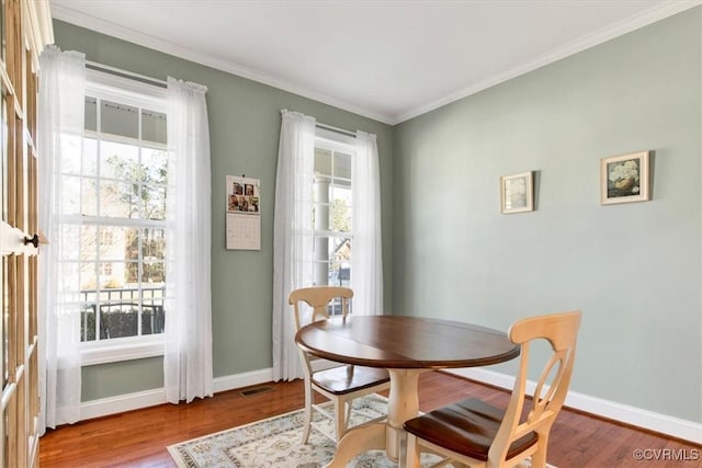 dining space with wood finished floors, a wealth of natural light, and baseboards