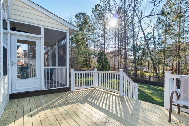 deck with a sunroom and fence