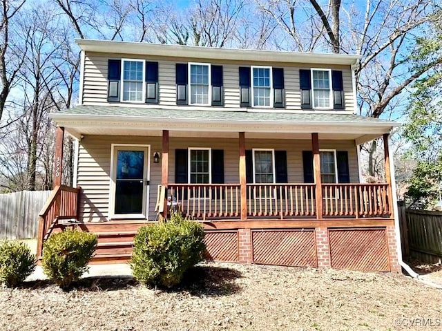 view of front of home featuring a garage, dirt driveway, roof with shingles, covered porch, and fence