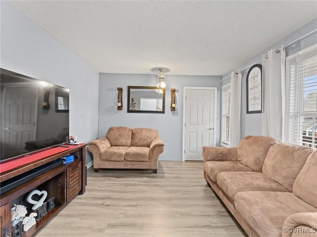 living area with a textured ceiling and light wood finished floors