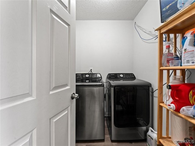 laundry room with laundry area, separate washer and dryer, a textured ceiling, and wood finished floors