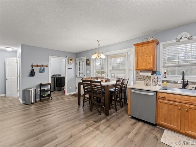 kitchen featuring a sink, light wood finished floors, a healthy amount of sunlight, and stainless steel dishwasher