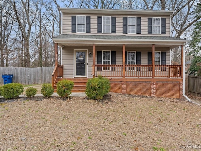 view of front facade featuring a porch, roof with shingles, and fence