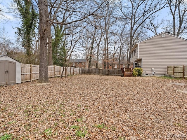 view of yard with a deck, a storage unit, an outdoor structure, and a fenced backyard