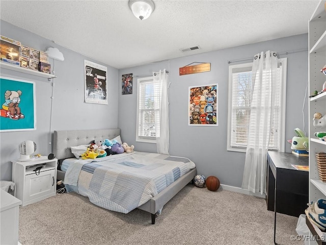 bedroom with a textured ceiling, carpet floors, visible vents, and baseboards