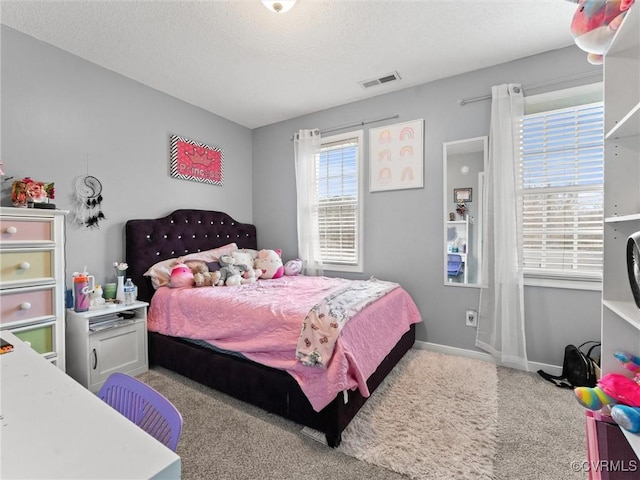 carpeted bedroom with baseboards, visible vents, and a textured ceiling