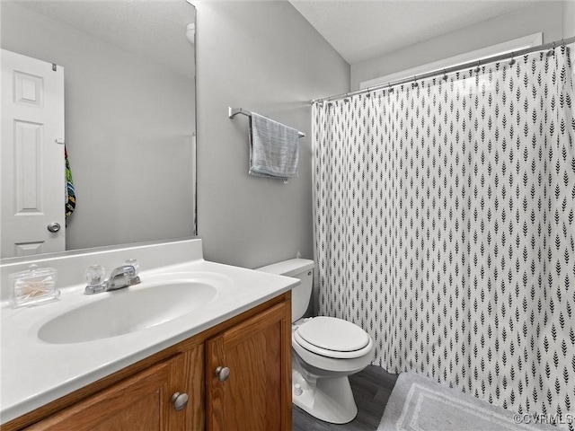 bathroom featuring toilet, curtained shower, and vanity