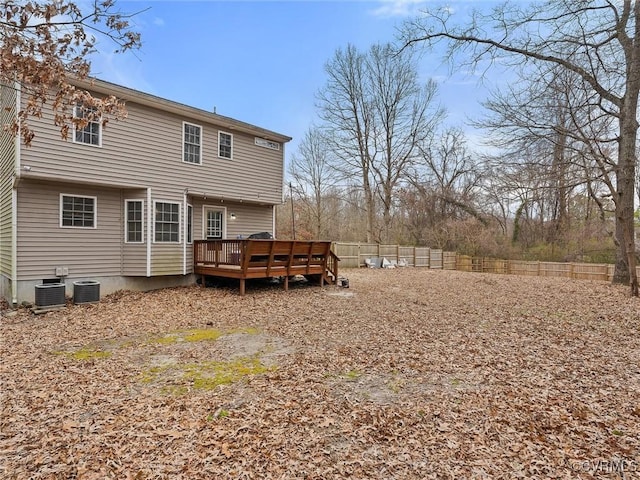 rear view of property with a fenced backyard, a deck, and central AC