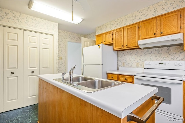 kitchen with wallpapered walls, under cabinet range hood, light countertops, brown cabinets, and white appliances