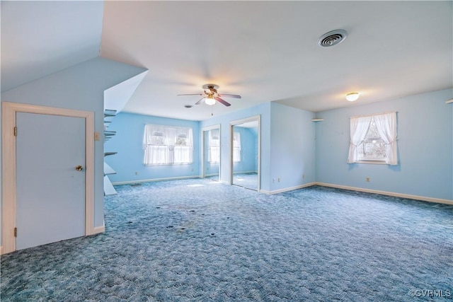 carpeted spare room with visible vents, baseboards, and a ceiling fan